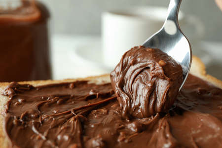 Spoon and bread with chocolate paste, close up and selective focusの写真素材