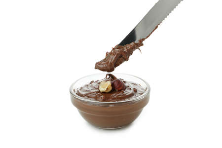 Bowl with chocolate paste and nuts, and knife isolated on white backgroundの写真素材