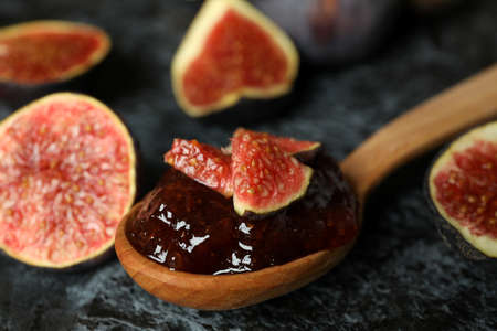 Spoon with fig jam and ingredients on black smokey backgroundの写真素材