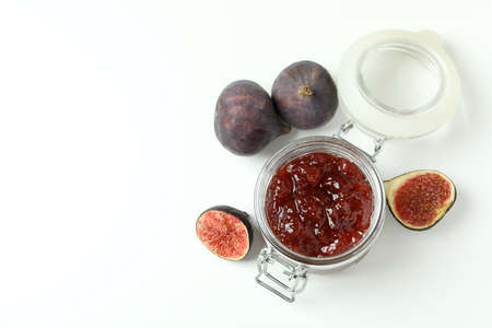 Jar with fig jam and ingredients on white backgroundの写真素材
