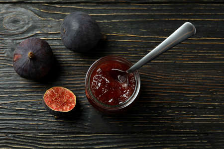 Jar with fig jam and spoon, and ingredients on wooden backgroundの写真素材