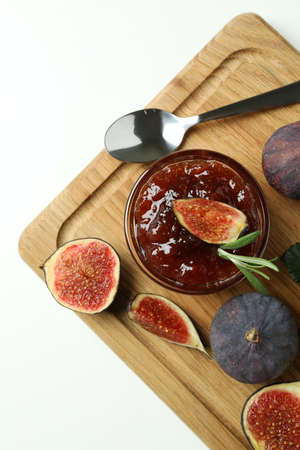 Board with fig jam, ingredients and spoon on white backgroundの写真素材