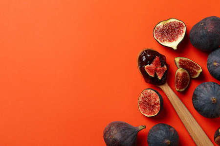 Spoon with fig jam and ingredients on orange backgroundの写真素材