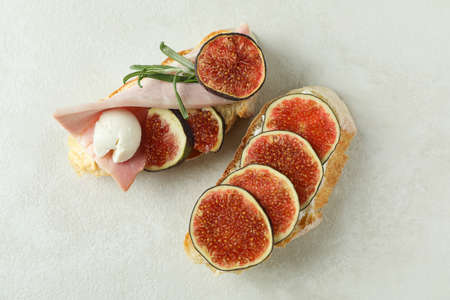 Tasty bruschetta with fig on white textured backgroundの写真素材