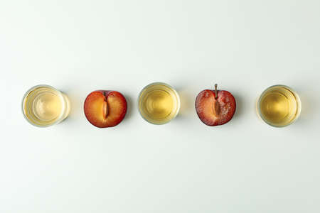 Plum vodka shots and ingredients on white backgroundの写真素材