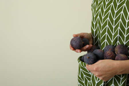 Woman holds fig in apron, space for textの写真素材