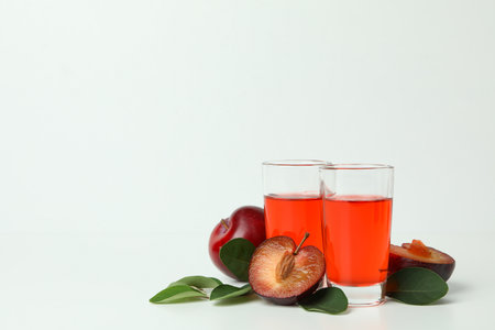 Plum brandy shots and ingredients on white backgroundの写真素材
