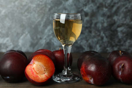 Plum vodka shot and ingredients on wooden tableの写真素材