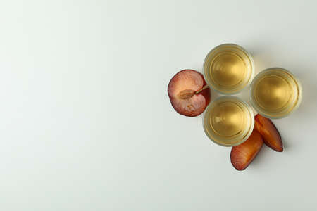 Plum vodka shots and ingredients on white backgroundの写真素材