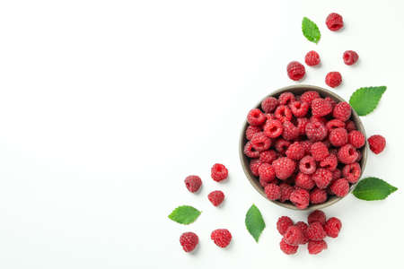 Red juicy raspberries in a bowl on a white background, space for text.の写真素材