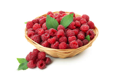 Red juicy raspberries in wicker vase, isolated on white background.