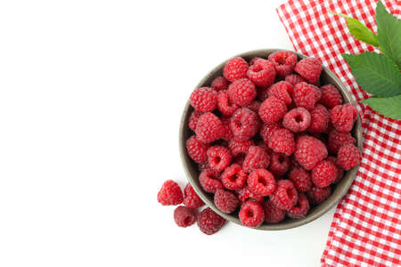 Red juicy raspberries in bowl and kitchen towel, isolated on white background.