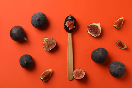 Spoon with fig jam and ingredients on orange backgroundの写真素材