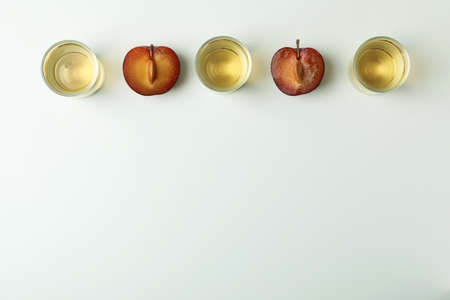 Plum vodka shots and ingredients on white backgroundの写真素材