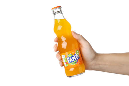 Odessa, Ukraine - September 23, 2021: Female hand holds Fanta bottle, isolated on white background.のeditorial素材