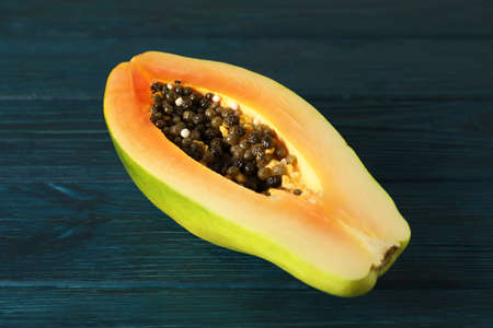 Half of papaya on dark blue wooden backgroundの写真素材