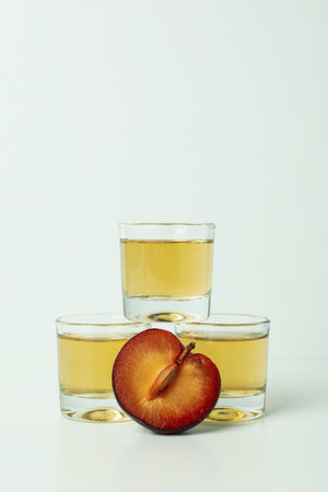 Plum vodka shots and ingredients on white backgroundの写真素材