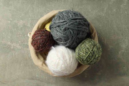 Wicker basket with yarn balls on light gray table