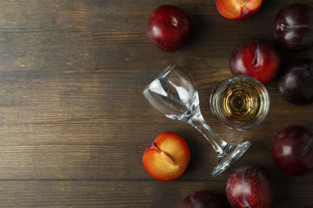 Plum vodka shot and ingredients on wooden tableの写真素材