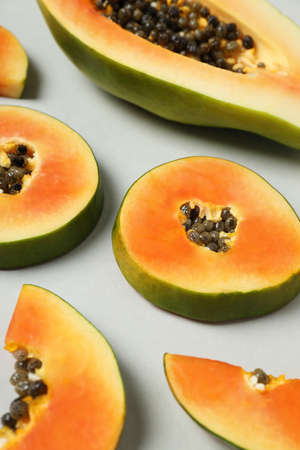 Fresh papaya slices on light gray background