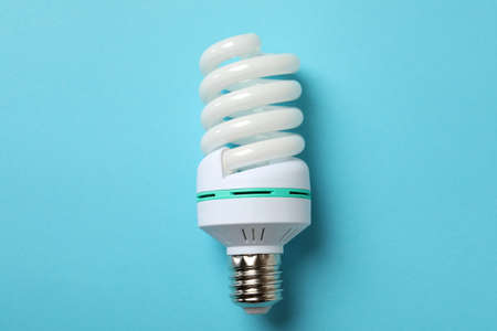 Energy saving bulb on blue background, close up.の写真素材