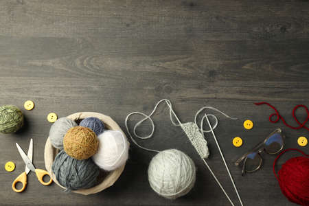 Concept of knitting with yarn balls on gray wooden tableの写真素材