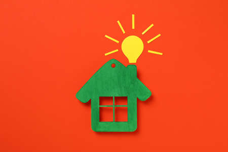 Green house with yellow bulb on red background.の写真素材