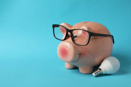 Energy saving concept with piggy bank on blue background.の写真素材