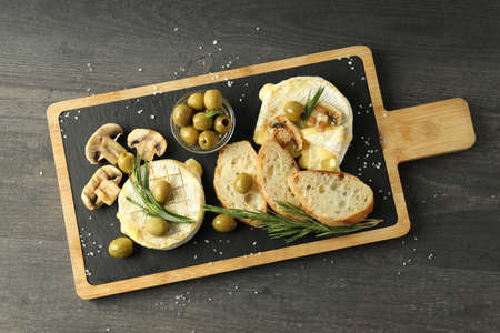 Concept of tasty food with grilled camembert on dark wooden background.の写真素材