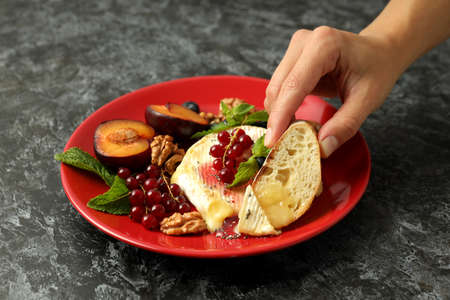 Concept of tasty food with grilled camembert on black smokey background.の写真素材