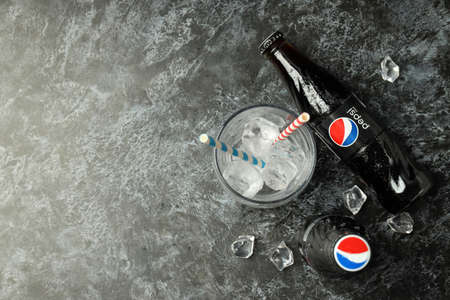 Odessa, Ukraine - September 23, 2021: Pepsi bottles, glass with straws and ice on dark background.のeditorial素材