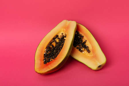 Halves of ripe papaya on pink backgroundの写真素材