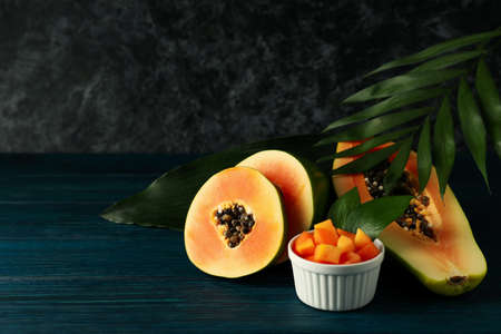 Fresh papaya with leaves on wooden table, space for textの写真素材