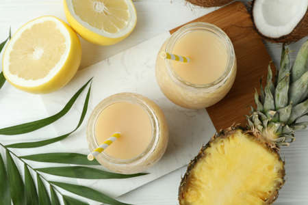 Pina colada cocktails and ingredients on white wooden table.の写真素材