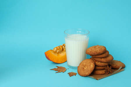 Milk and pumpkin cookies on blue background.の写真素材