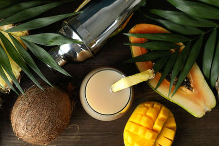 Pina colada cocktail and ingredients on wooden table.の写真素材