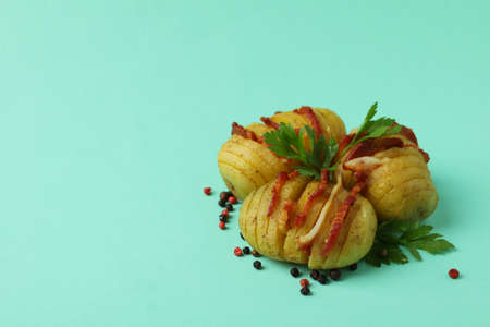 Baked potato with bacon on mint background.の写真素材