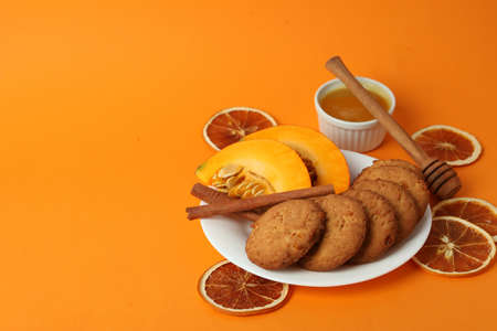 Concept of tasty food with pumpkin cookies on orange background.の写真素材