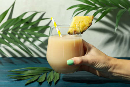 Female hand holds pina colada cocktail, close up.の写真素材