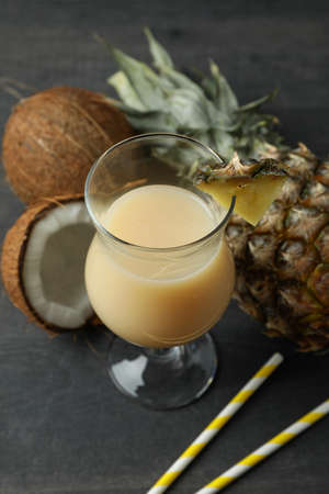 Pina colada cocktail and ingredients on dark wooden table.の写真素材