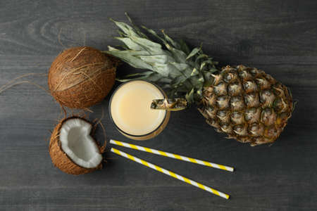 Pina colada cocktail and ingredients on dark wooden table.の写真素材