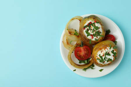 Plate with baked potato on blue background.の写真素材