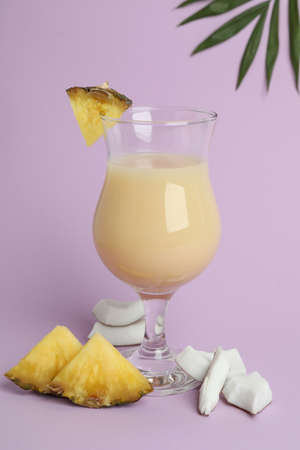 Pina colada cocktail and ingredients on violet background.の写真素材