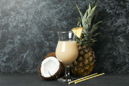 Pina colada cocktail and ingredients against black smoke background.の写真素材