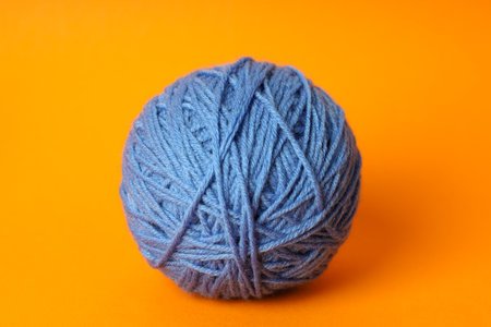 Blue ball of yarn on orange backgroundの写真素材