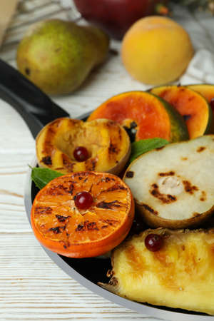 Concept of tasty food with grilled fruits on white wooden table.の写真素材