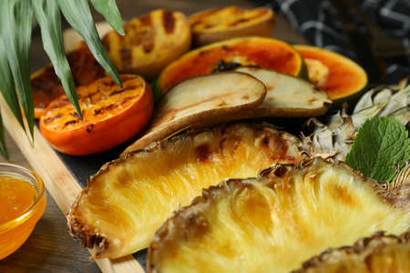 Concept of tasty food with grilled fruits on wooden background.の写真素材