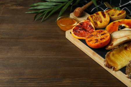 Concept of tasty food with grilled fruits on wooden background.の写真素材
