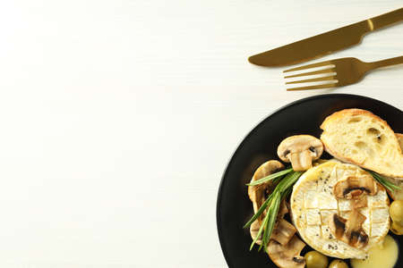 Concept of tasty food with grilled camembert on white wooden background.の写真素材