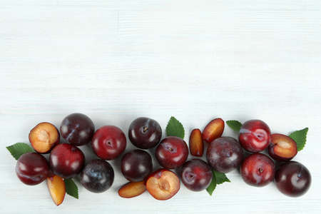 Flat lay composition with plums on white wooden background.の写真素材